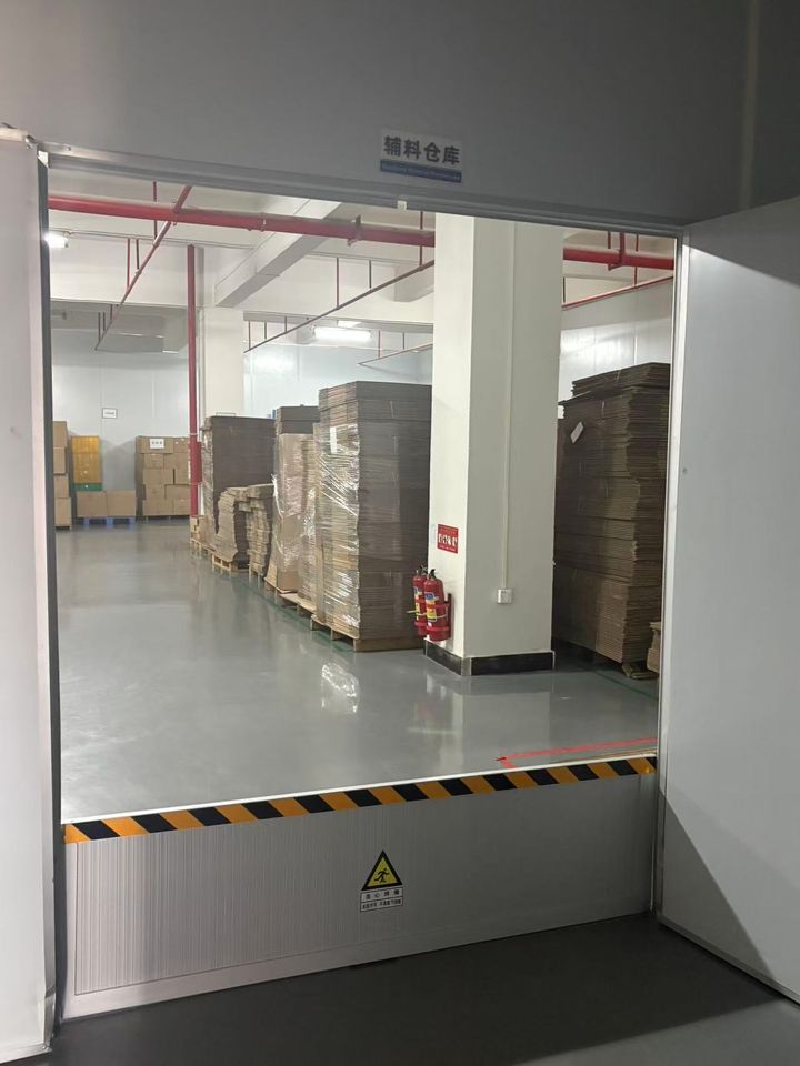Loading area with pallets of flat cartons and a fire extinguisher by the door.