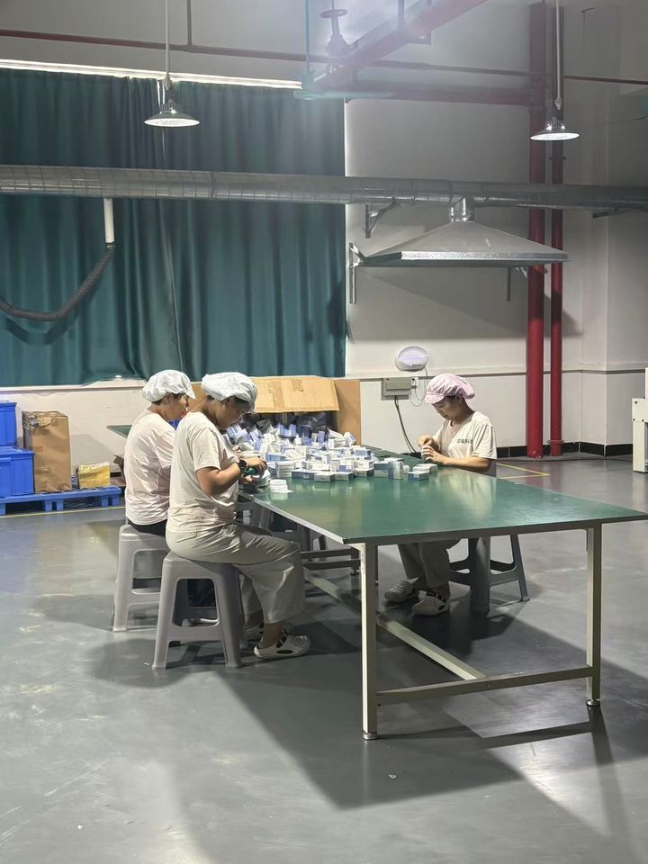 Green packing table where whitening pens are boxed by hand.