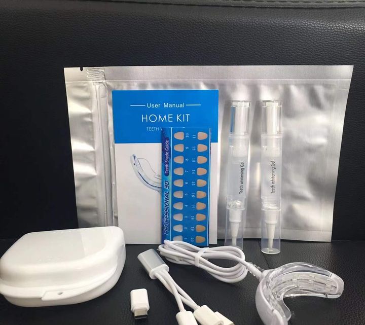 Whitening kit laid out: foil pouch, insert card, shade card, storage case, two pens, three-way cable and the LED tray.
