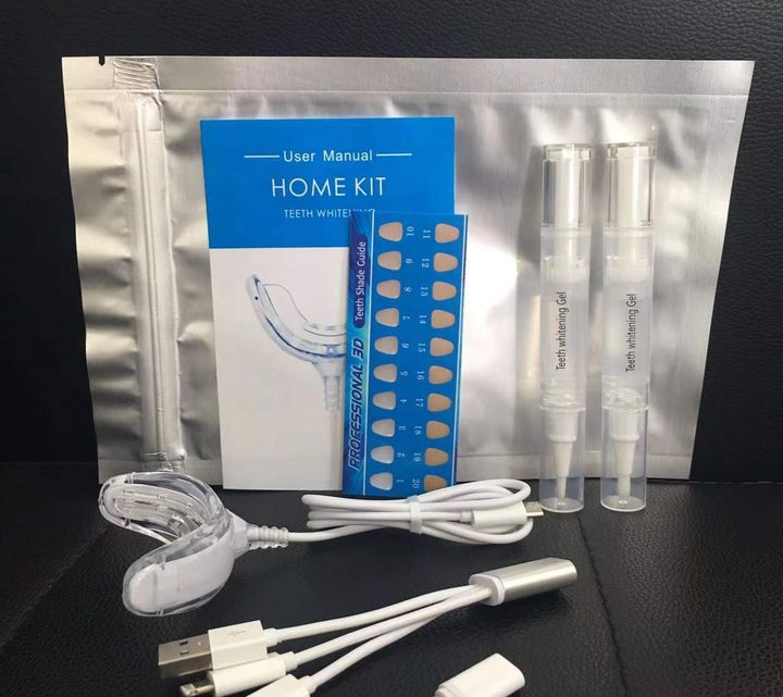 Whitening kit laid out with its pens, cable, tray and case, from the side.