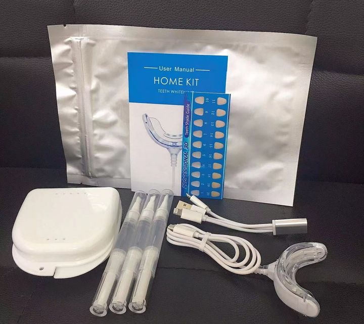 Whitening kit in a foil pouch laid out: storage case, pens, LED tray, cable, insert card and shade card.