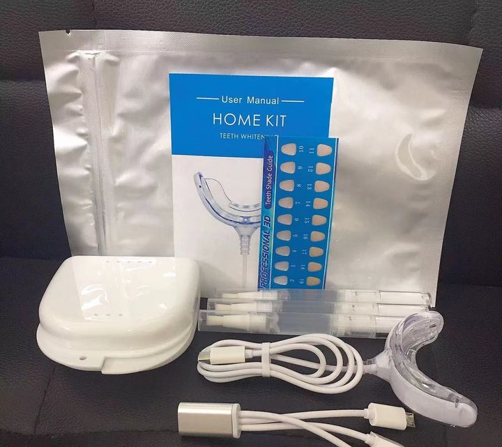 Whitening kit laid out with its pouch, case, pens, tray and cable.
