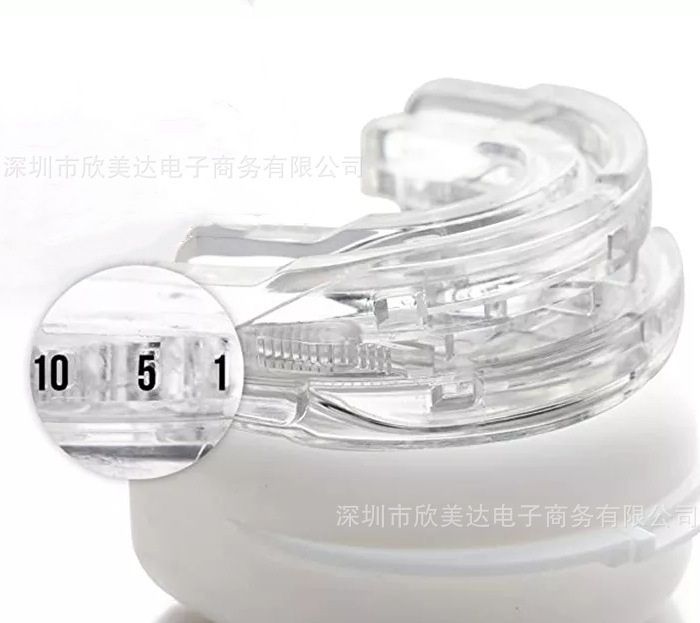 Clear adjustable mouthpiece on its white case, with a magnifier over the graduated scale.